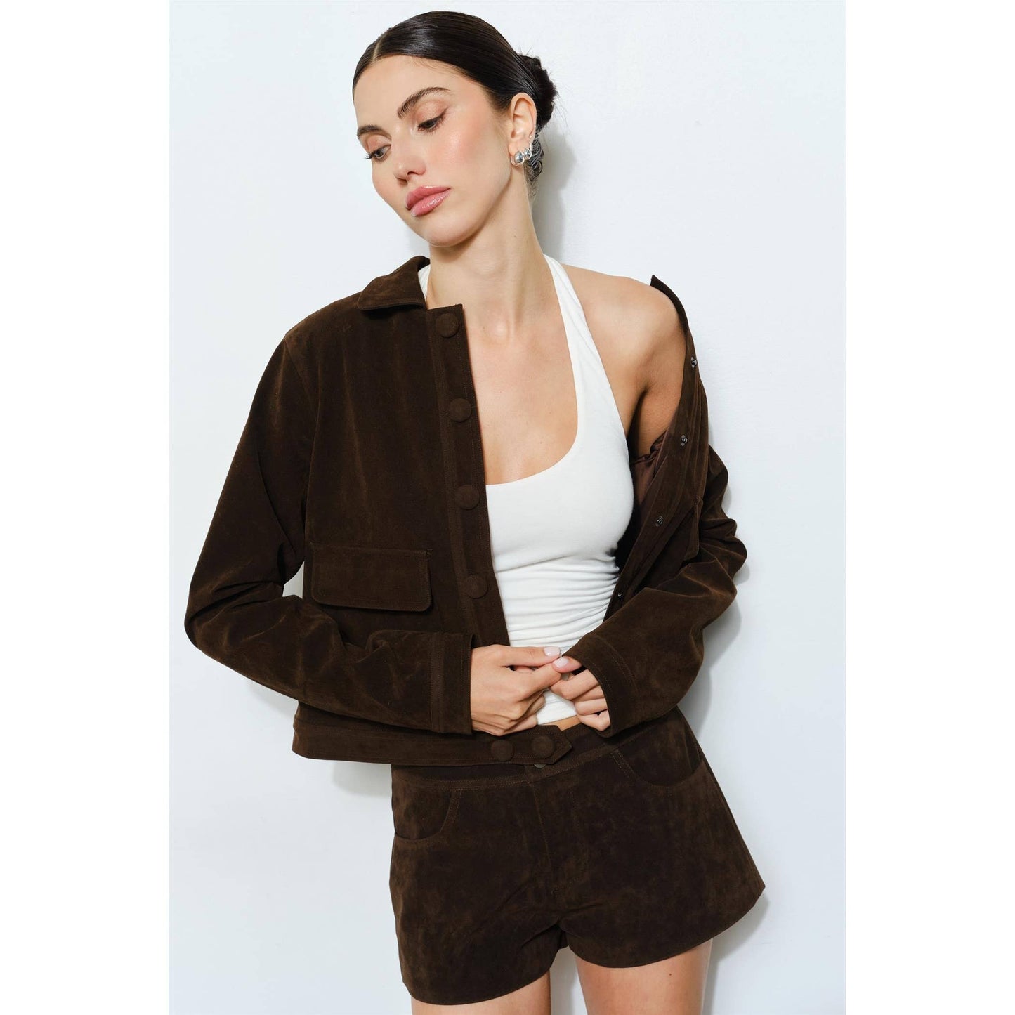 Brown suede jacket with button closure, paired with white tank top and matching shorts.