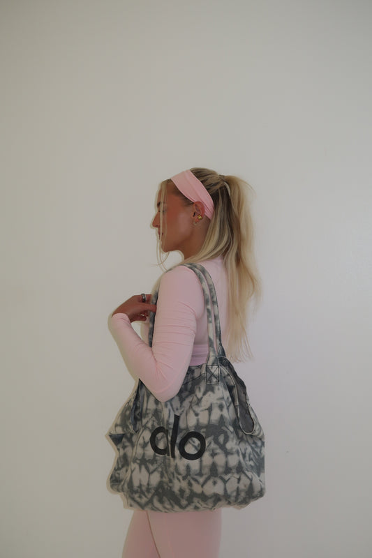 Person wearing a patterned dress with 'olo' branding on a plain background