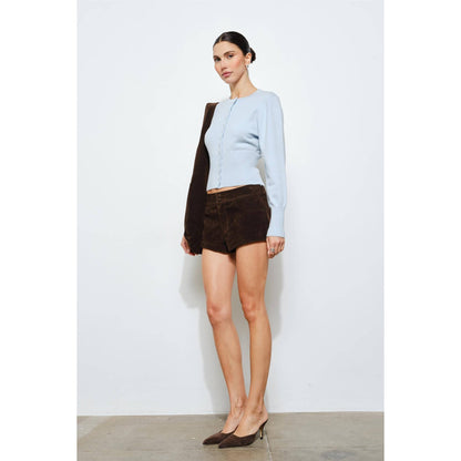 Light blue knitted cardigan with brown suede shorts and matching heels, perfect for stylish casual wear.