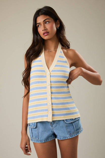 Woman wearing a striped halter top and denim shorts against a neutral background