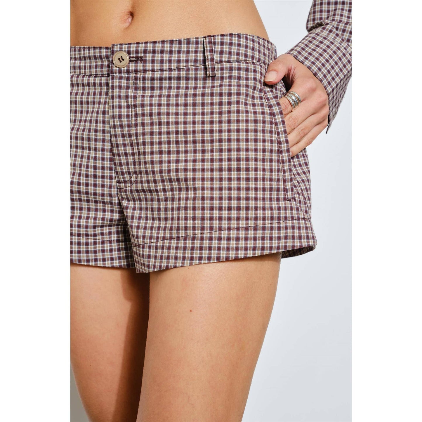 Stylish brown plaid shorts with side pockets and button detail, perfect for summer outings.