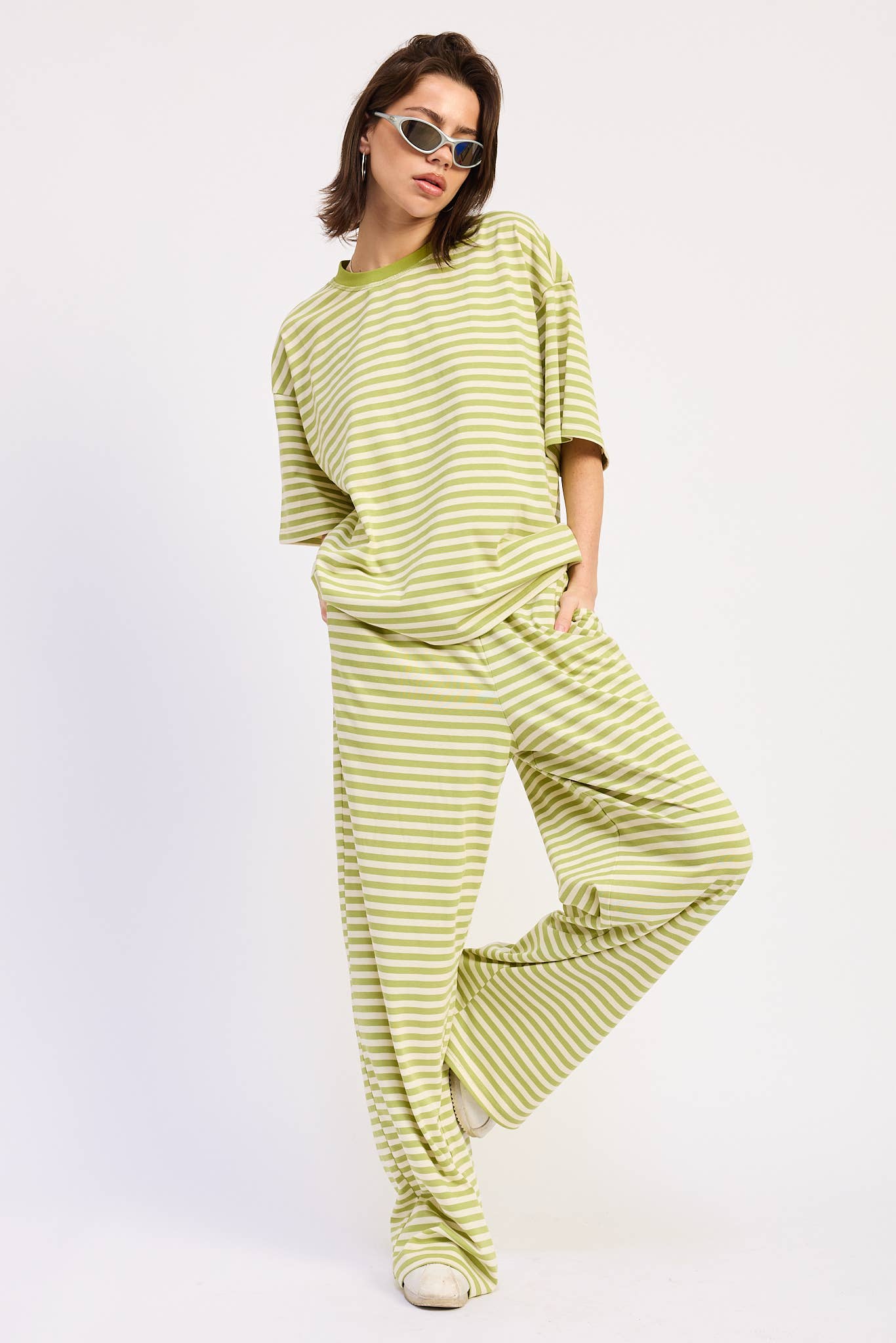 Woman wearing a green and white striped outfit on a white background