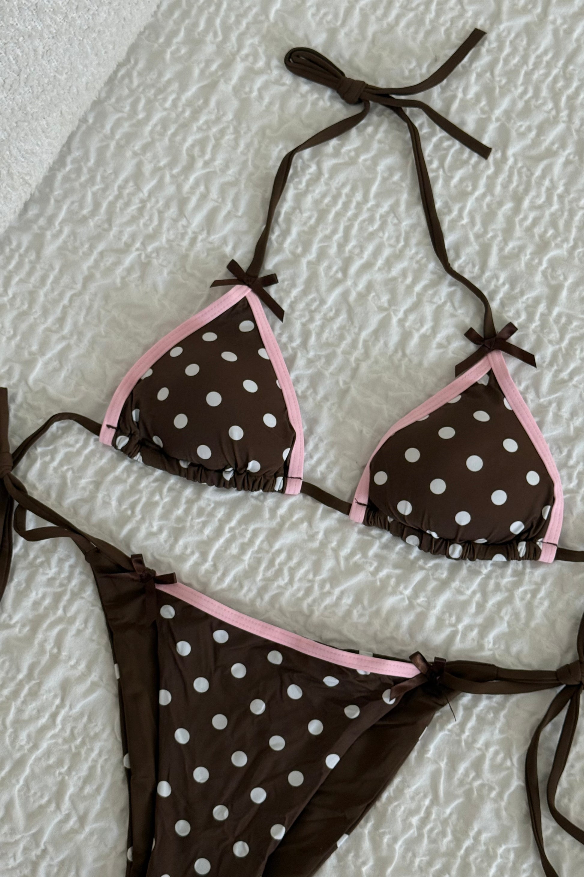 Brown polka dot bikini set with pink trim, made from soft material, featuring tie-side bottoms.