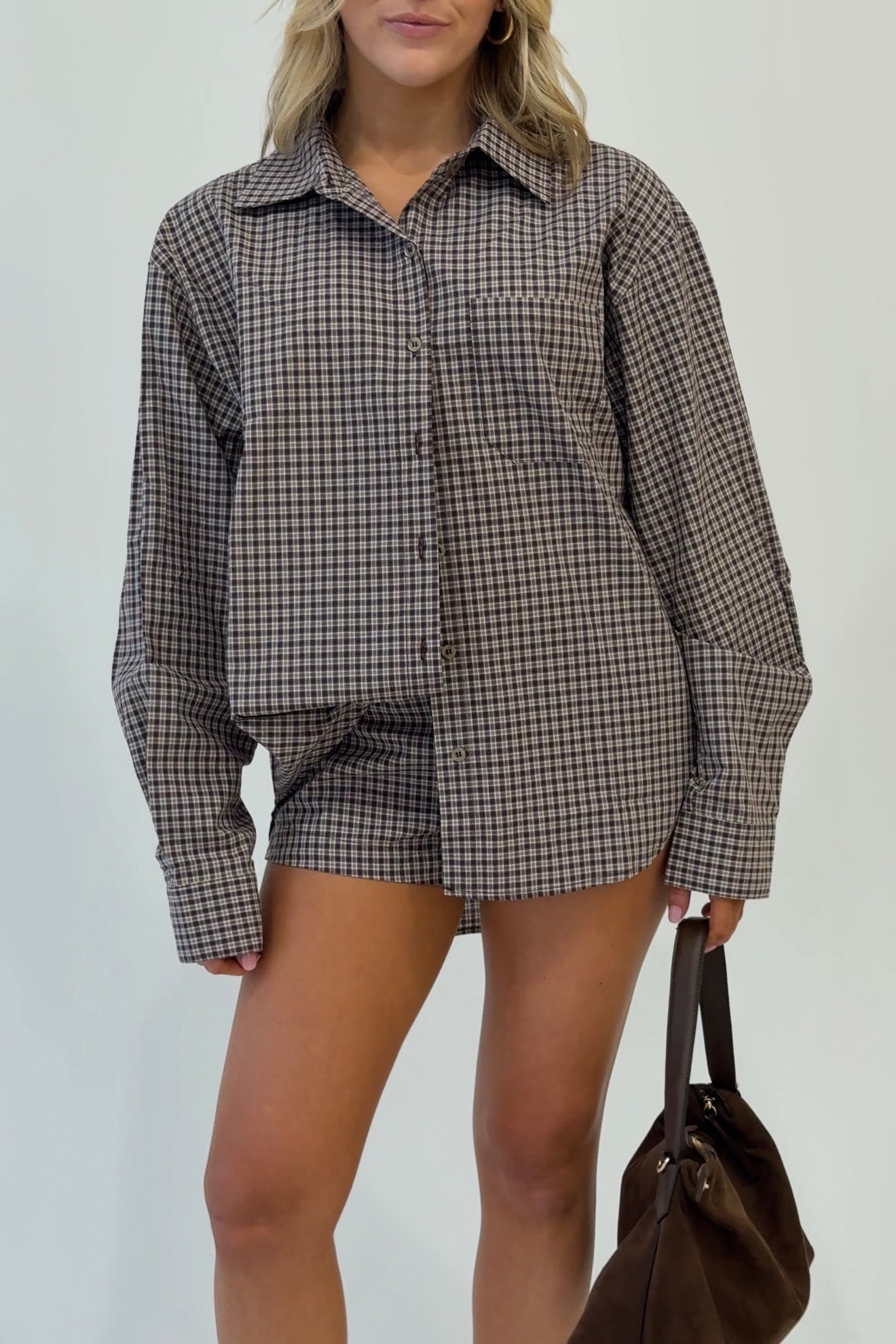 Women's brown plaid button-up shirt in soft fabric, featuring a pocket; styled with matching shorts.
