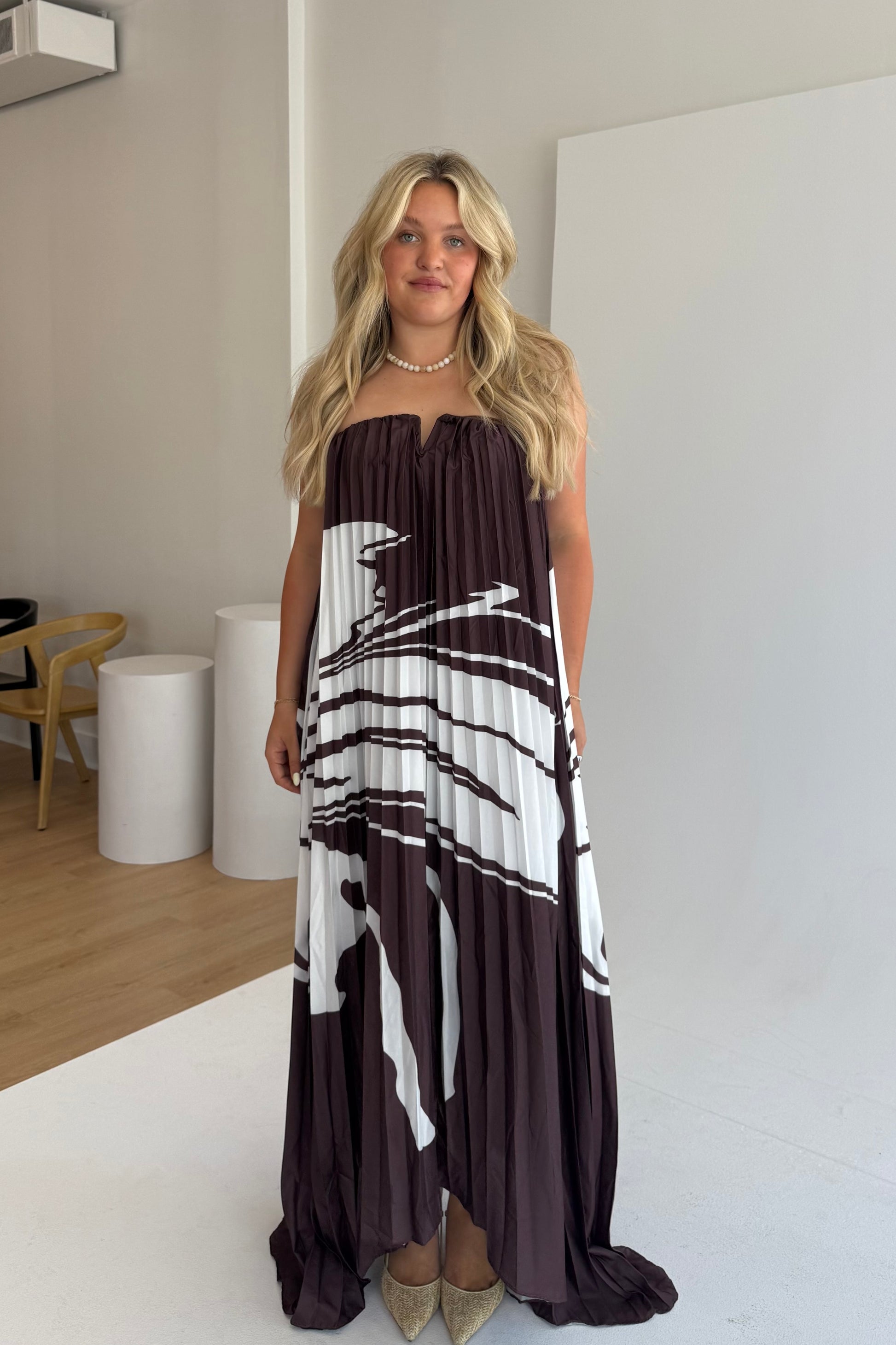 Woman wearing a strapless dress with black and white pattern in an indoor setting