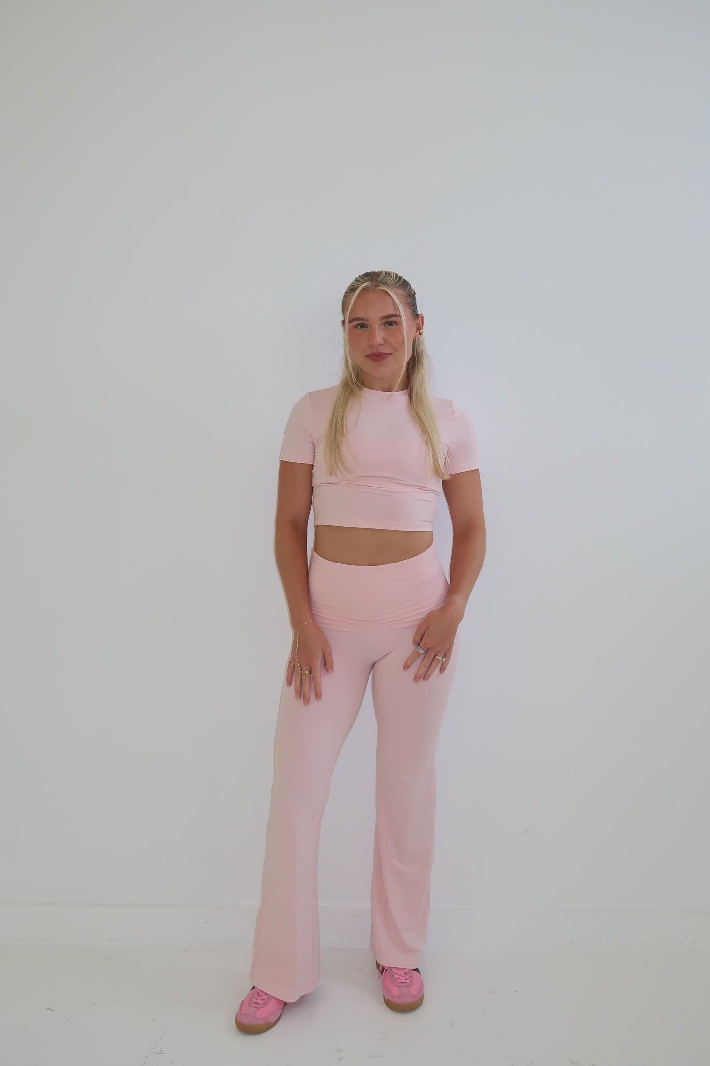 Person wearing a pink outfit on a white background