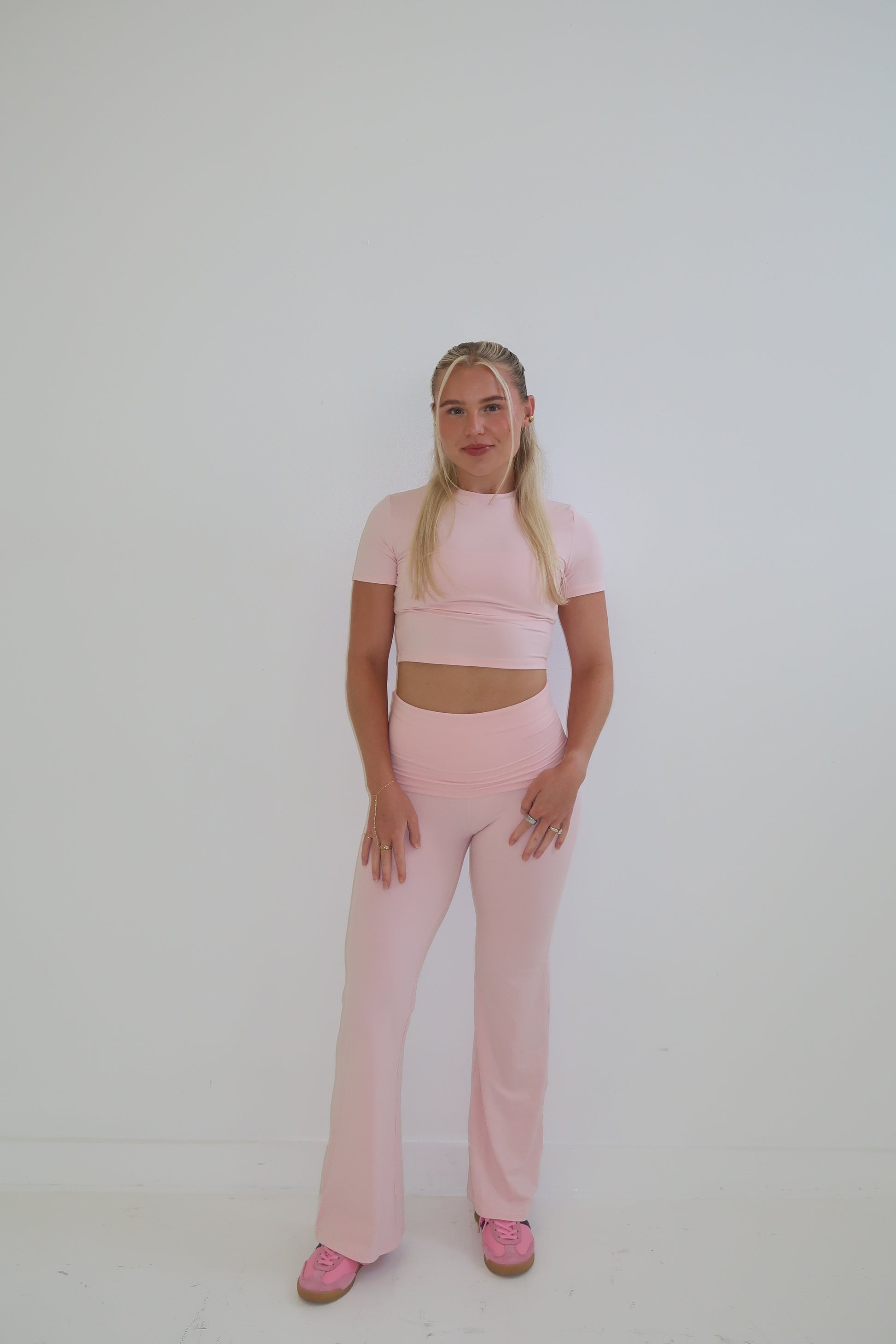 Person wearing a pink outfit on a white background