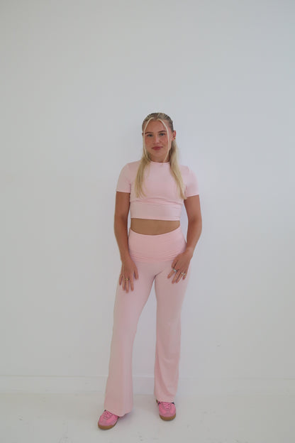 Person wearing a pink outfit on a white background