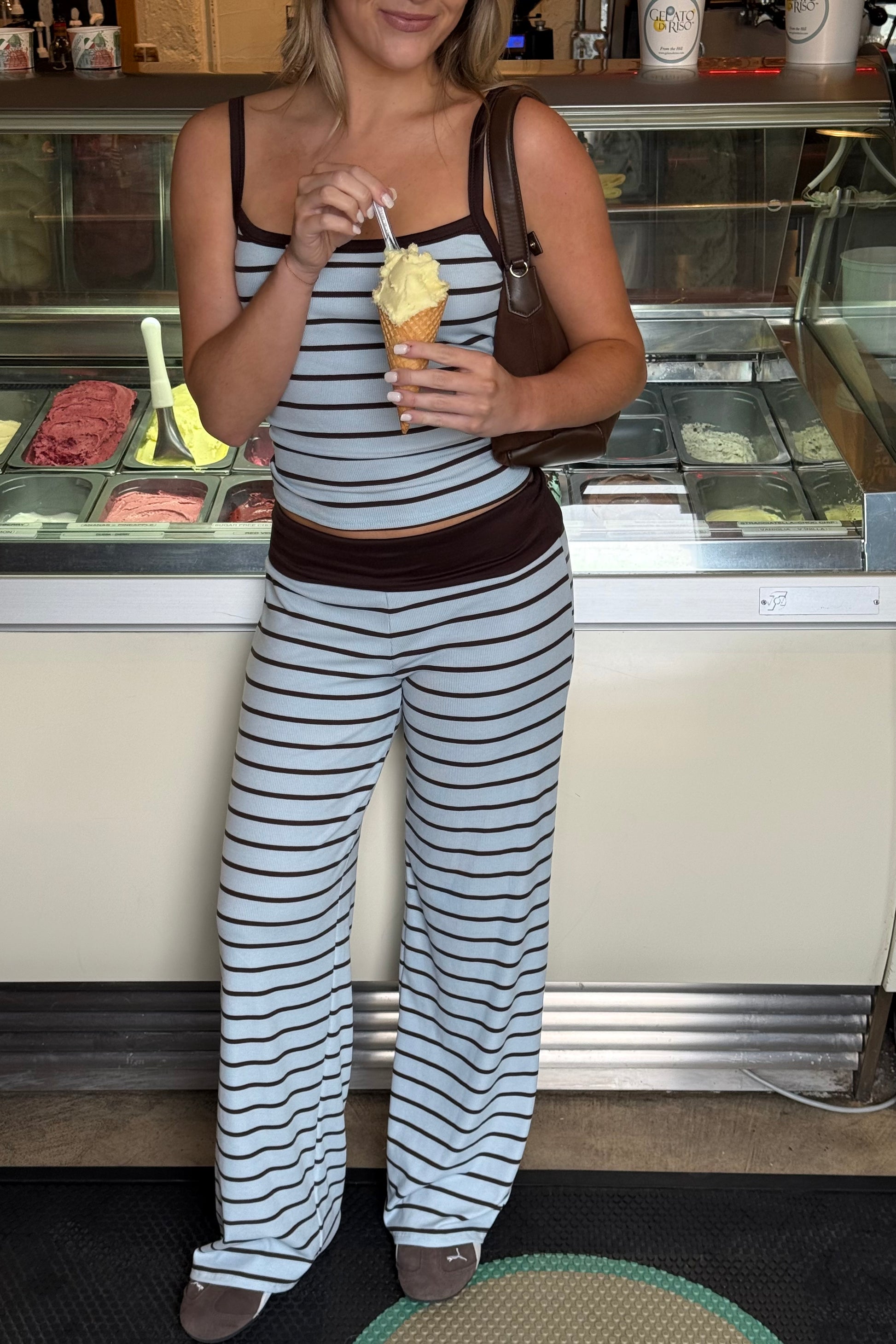 Woman in striped outfit eating ice cream at a counter