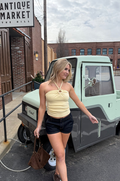 Woman standing in front of a vintage truck with an 'Antique Market' sign in the background.