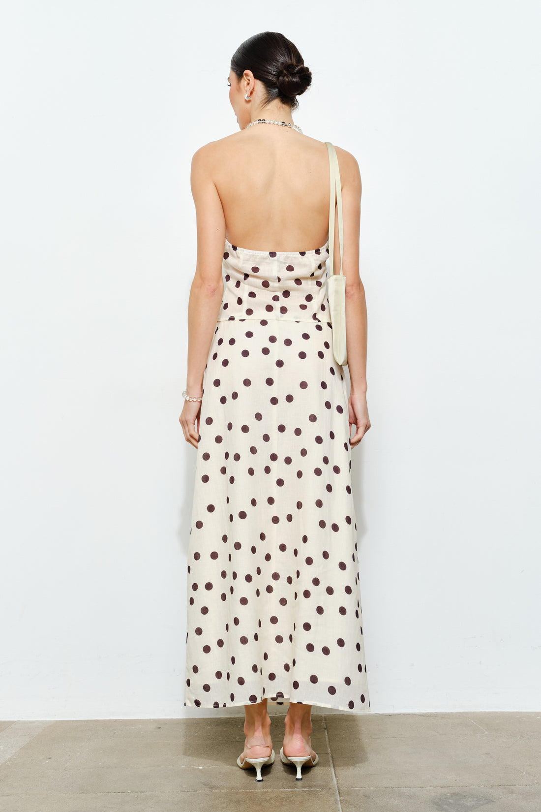 Woman wearing a polka dot dress with a plain background