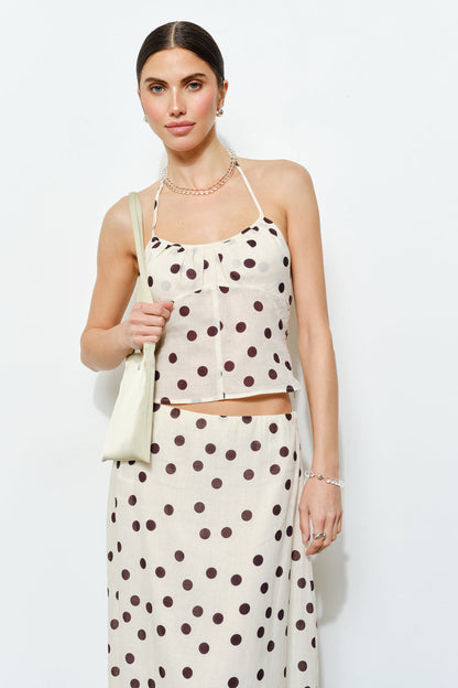 Woman wearing a polka dot dress with a white background