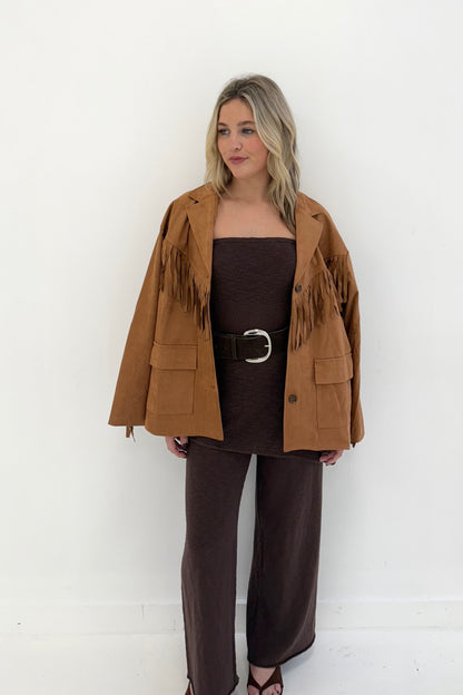 Brown suede fringed jacket styled with a brown outfit, perfect for a trendy, bohemian look.