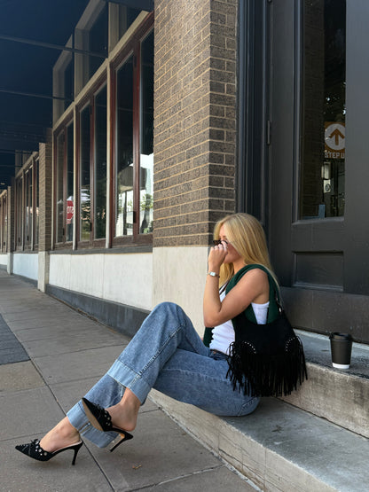 Person walking on a sidewalk with a building entrance in the background