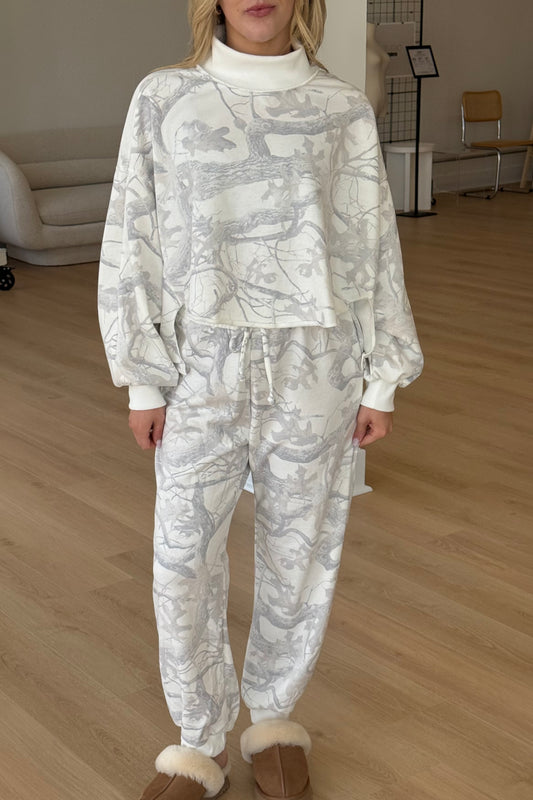 Person wearing a white patterned outfit in an indoor setting