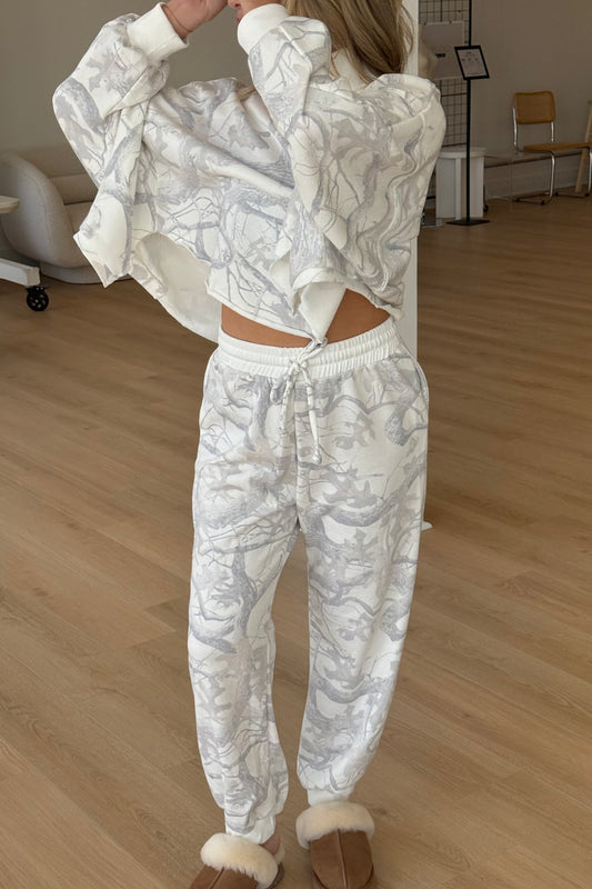 Person wearing a white patterned tracksuit in an indoor setting