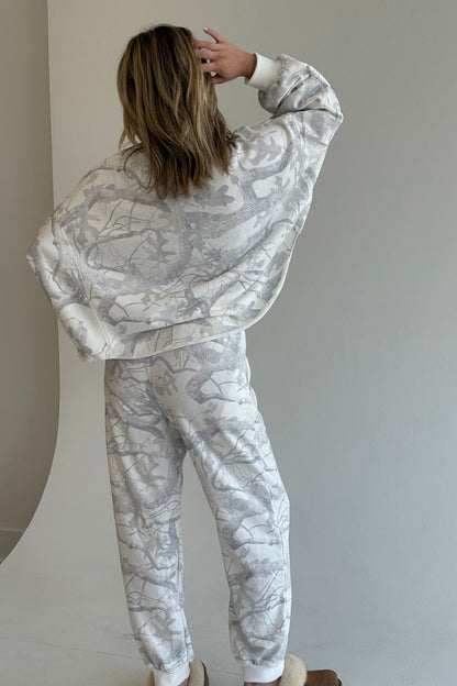 Person wearing a matching marble-patterned outfit against a plain background