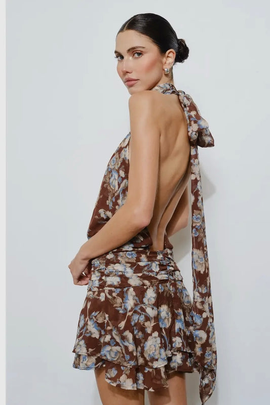 Brown floral halter neck dress with backless design, ruffled hem, and lightweight material.