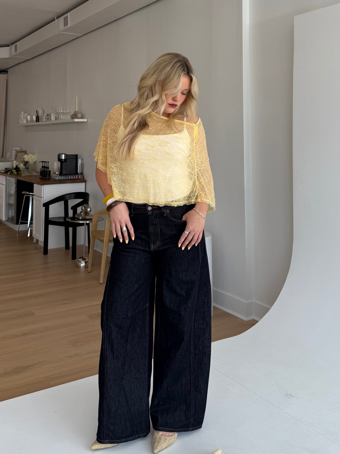 Woman wearing a yellow top and black pants in an indoor setting