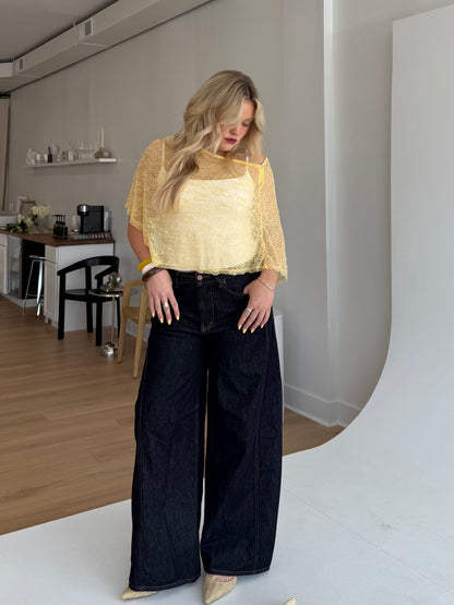 Woman wearing a yellow top and black pants in an indoor setting