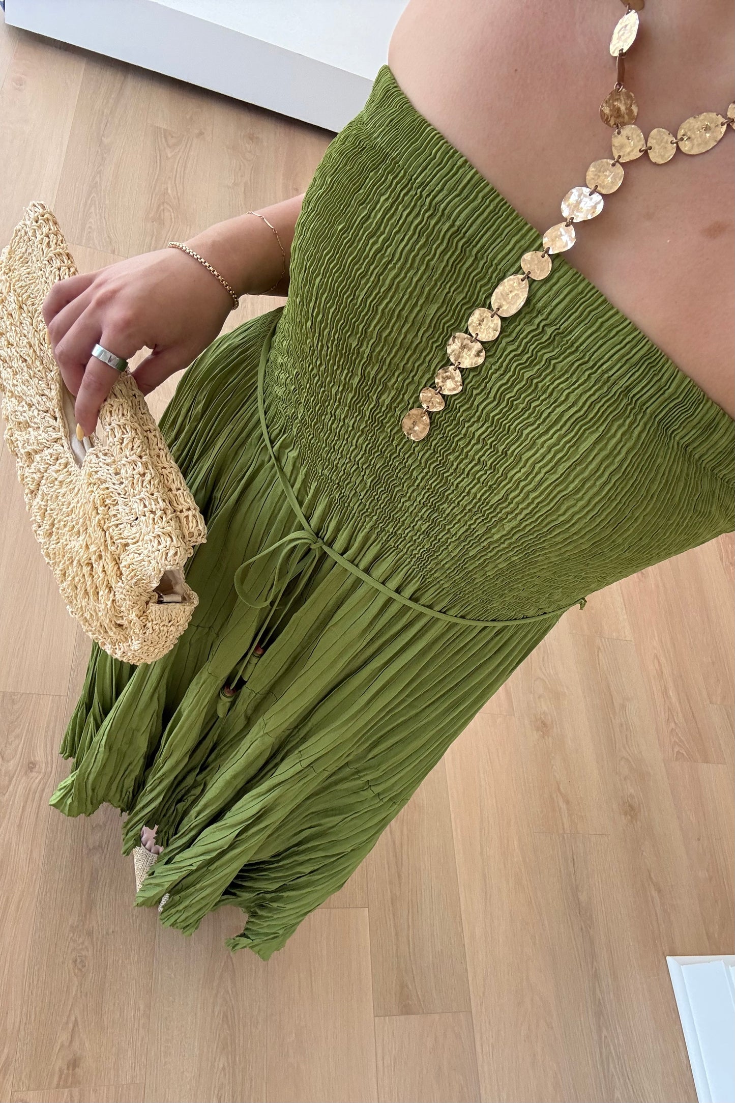 Green fringe dress with gold buttons on a wooden floor