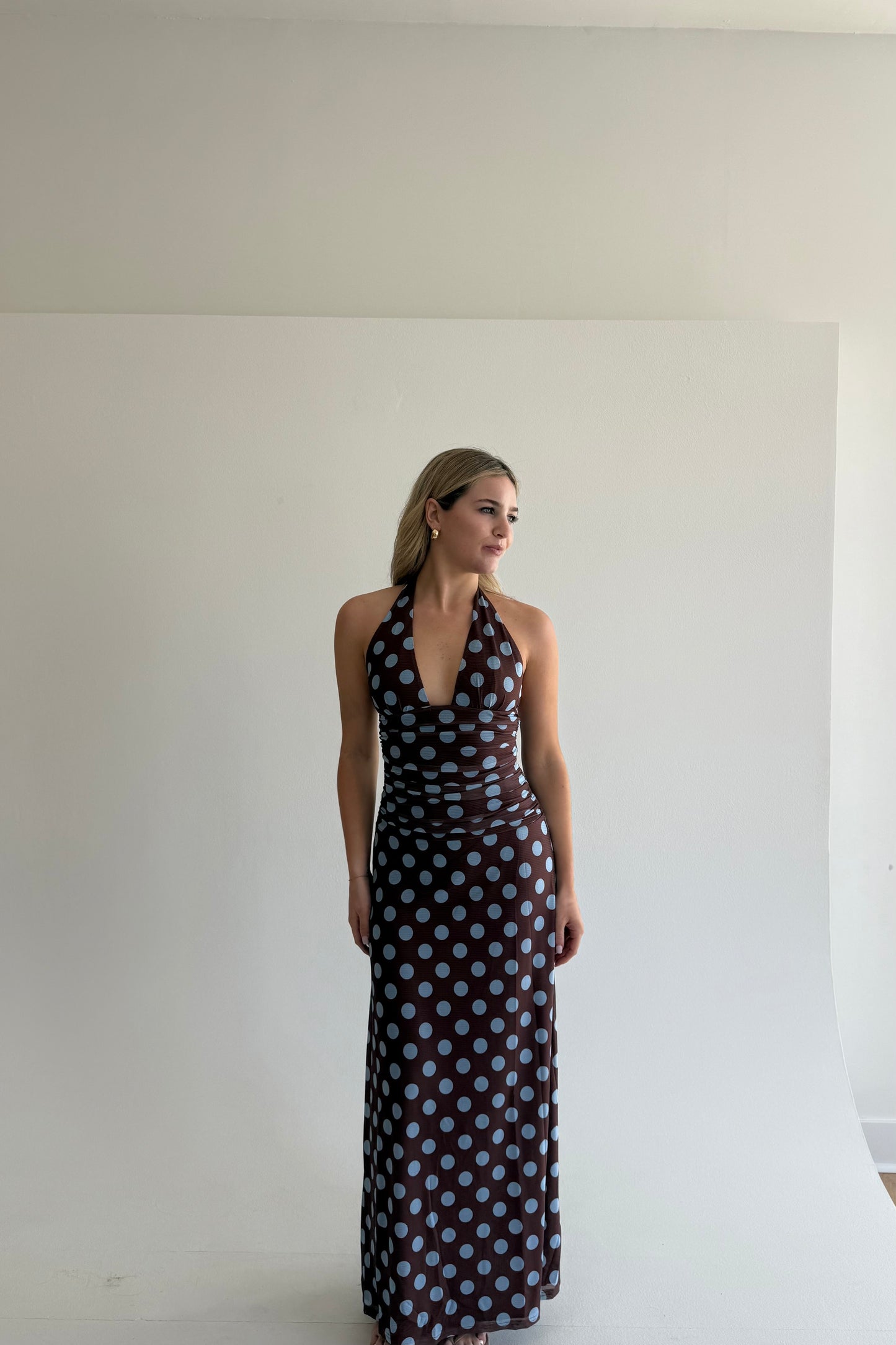 Woman wearing a polka dot dress against a plain white background