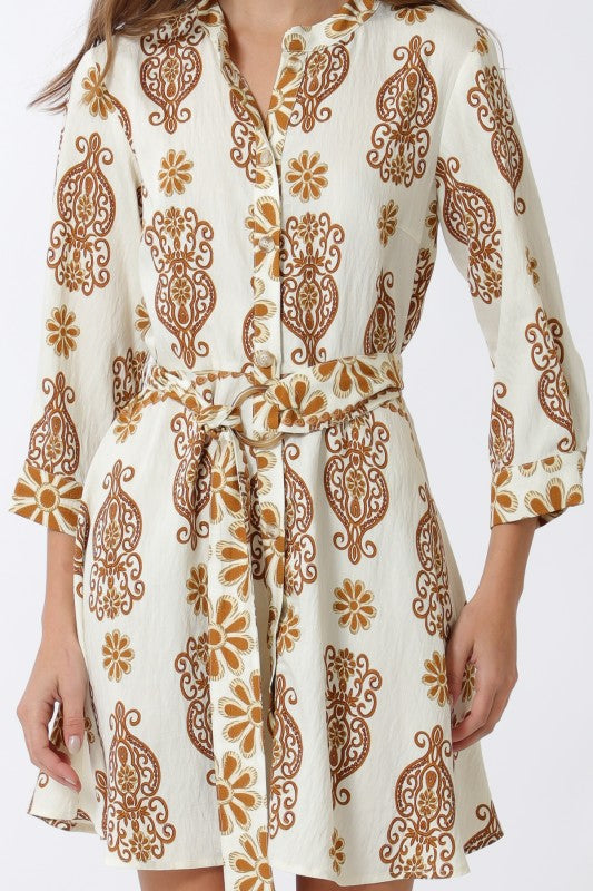 White dress with brown floral pattern worn by a person on a white background