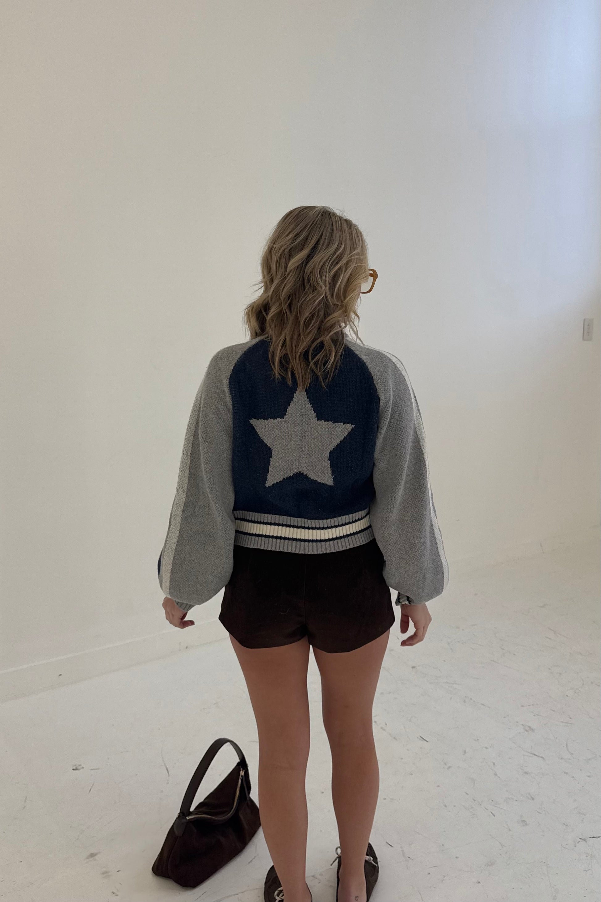 Stylish cropped jacket with gray and navy star design, perfect for casual outfits.