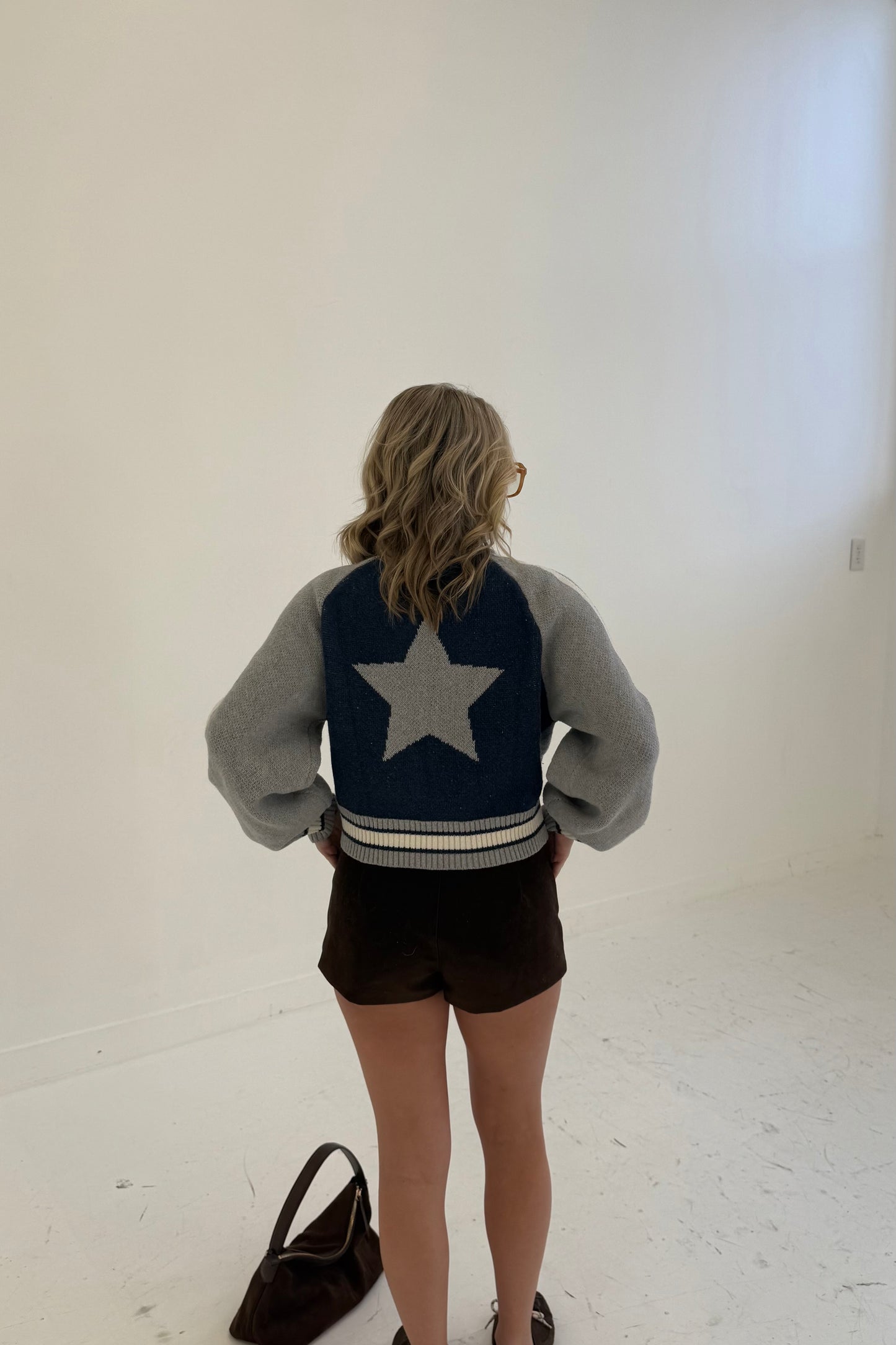 Grey and navy star-patterned cropped sweater, featuring puff sleeves and striped hem.