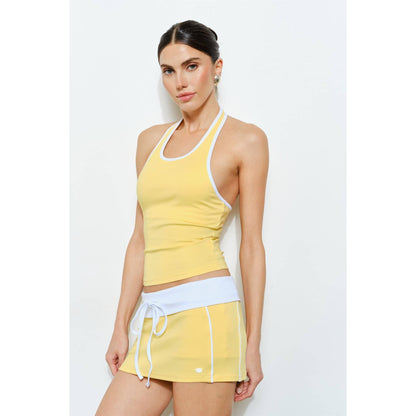 Woman wearing a yellow tank top and skirt set on a white background