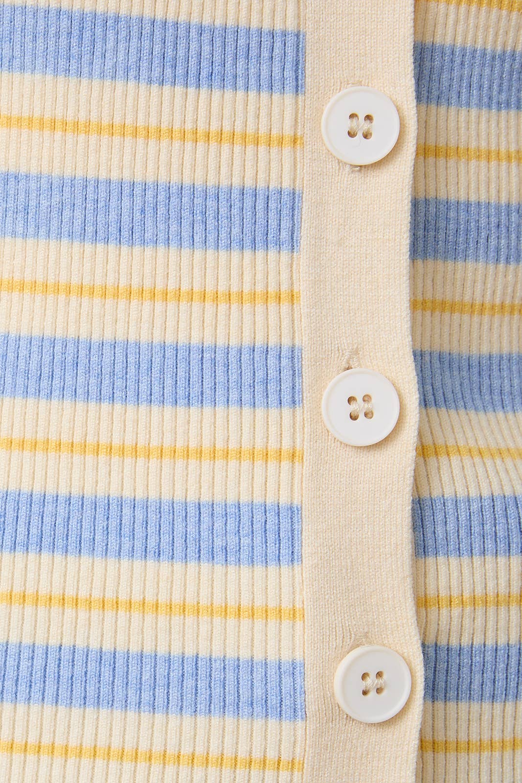 Close-up of a striped shirt with buttons on a beige background