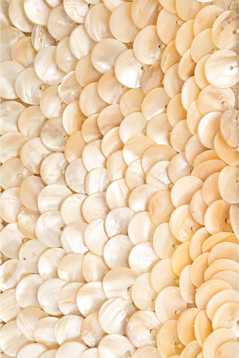 Close-up of a textured wall made of circular beige stones.